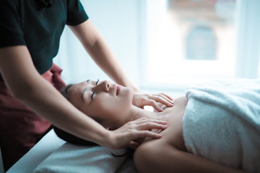 A serene spa massage session with a woman relaxing on a table, receiving a calming neck massage.